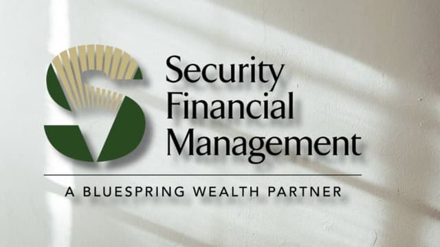 Security Financial Management logo on wall with “A Bluespring Wealth Partner” tagline and soft window light shadows.