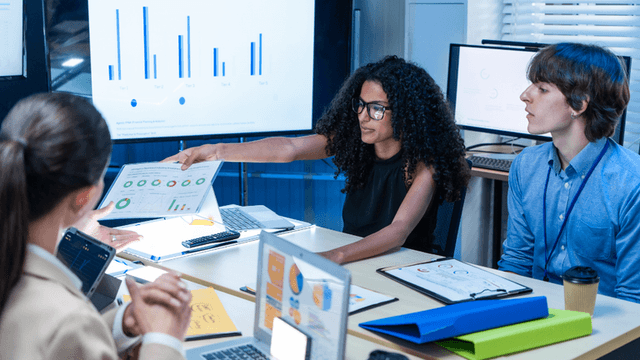 Business team reviewing AI performance charts and analytics during a technology strategy meeting.
