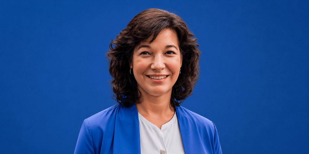 Dr. Leott smiles in a blue blazer against a blue background, representing her women's health education platform.