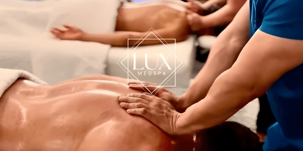 Massage therapist applying oil to client's back at Lux MedSpa treatment room.