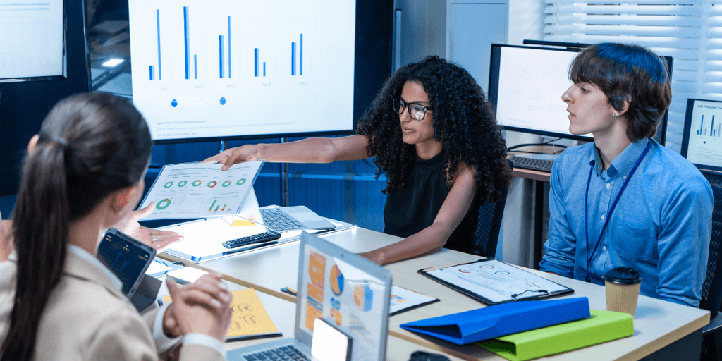 Business team reviewing AI performance charts and analytics during a technology strategy meeting.