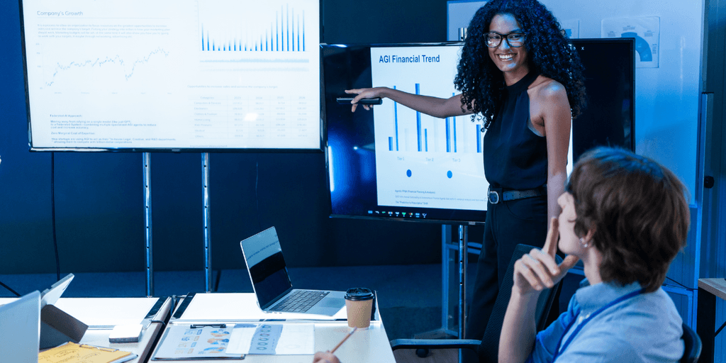 Presenter pointing to financial charts on digital displays during an AI business presentation.