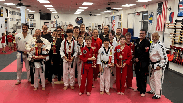 "Grandmaster Spillmann with students celebrating martial arts achievements, leadership, and community impact at Global Martial Arts USA."