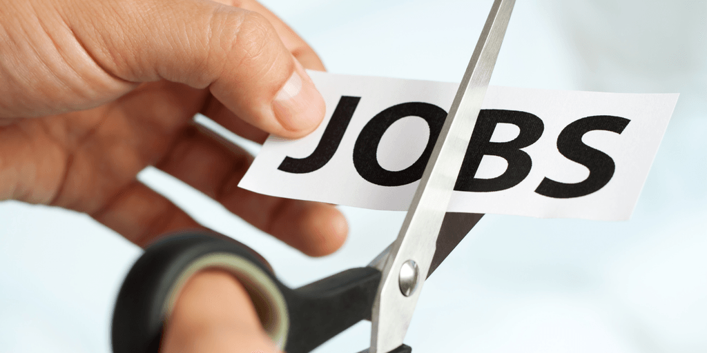 A hand using scissors to cut a paper with the word "JOBS" on it