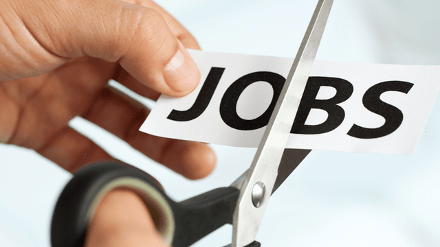 A hand using scissors to cut a paper with the word "JOBS" on it