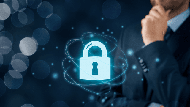 A businessman contemplating cybersecurity with a digital lock symbol on a blue background