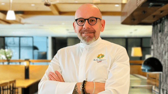 Chef Eric Truglas smiling in a restaurant, representing resilience and mentorship behind his Stolen Knives culinary philosophy.