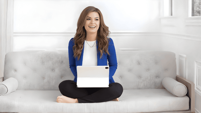 Victoria S. Crosby smiling while working on a tablet, ready to help writers achieve success.