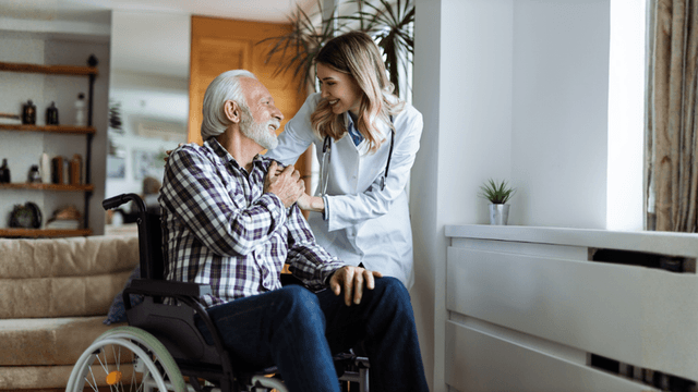 Caregiver offering compassionate support to an elderly man in a wheelchair, symbolizing the importance of healthcare and living benefits.