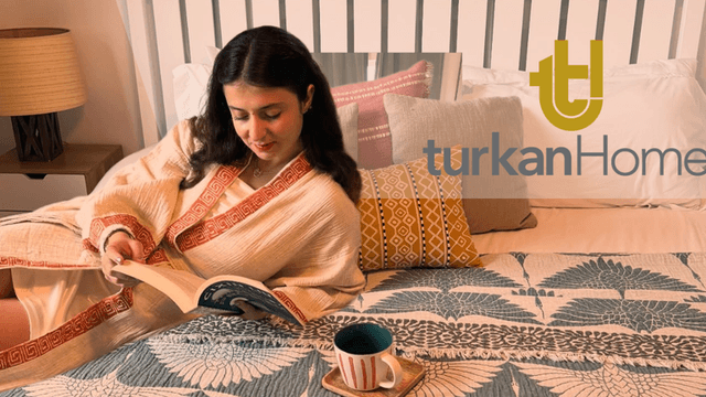 A cozy bedroom featuring TurkanHome textiles, including a decorative blanket, cushions, and a woman reading, embracing mindful living.