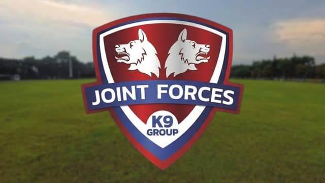 Joint Forces K9 Group logo displayed over a grassy training field.