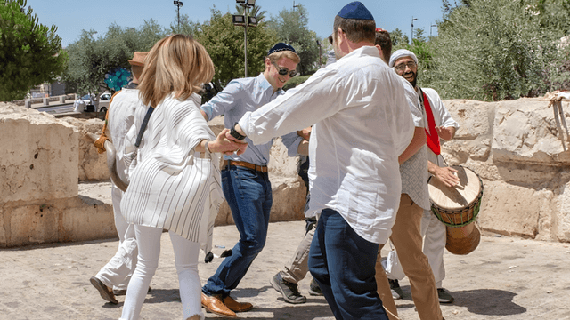 People dancing joyfully during a Bar Mitzvah celebration in Israel with live music and traditional dress.