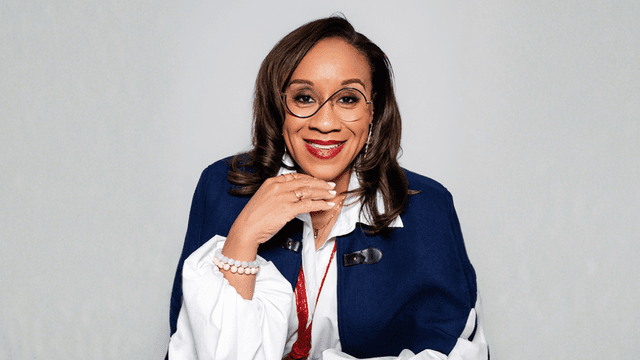 Jasmine McLeod smiling, dressed in blue, promoting empowerment and self-leadership for high-capacity women.