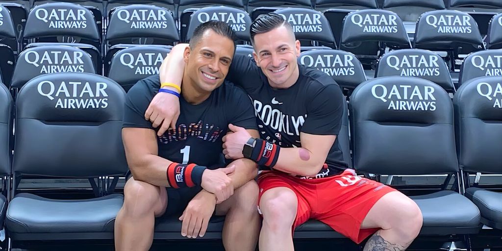 Anthony Espo and Jose Cordero sitting on a stadium bench, reflecting on their journey in building Bad Ass Academy in Brooklyn.