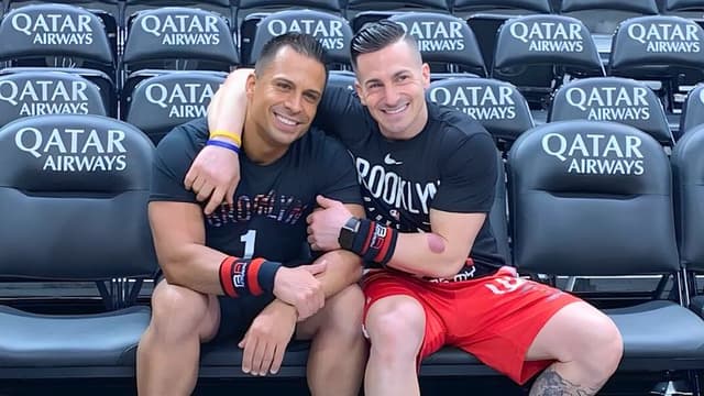 Anthony Espo and Jose Cordero sitting on a stadium bench, reflecting on their journey in building Bad Ass Academy in Brooklyn.