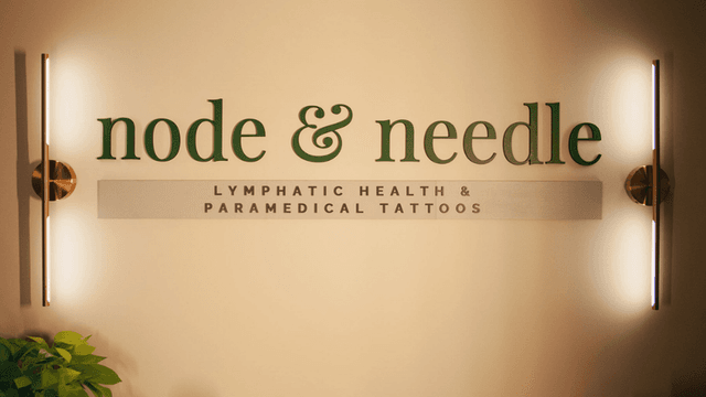 The sign for "Node & Needle" showcasing lymphatic health and paramedical tattoos, with modern lighting and greenery accents.
