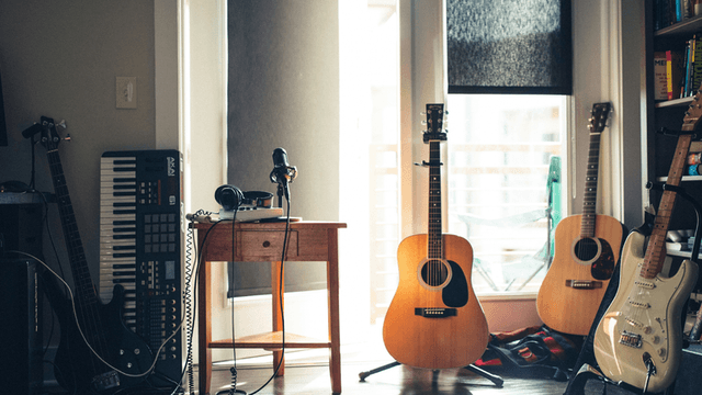 A creative music workspace featuring guitars, keyboard, and microphone, reflecting Poppy Bone's musical journey and artistic production environment.