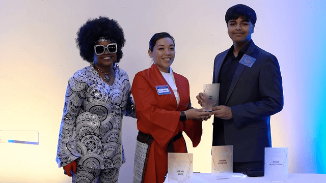 Three students receive an award for their "Home Of My Own" app, raising awareness about homelessness through technology.