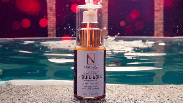 "NAHAia Active Organics 24K Gold Nourishing Oil, with luxurious organic ingredients and energy-infused skincare, set against a serene pool background."
