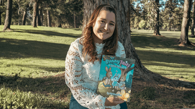 Pali Bermúdez, author and founder of Bunny Tails, holding her bilingual children's book, promoting emotional growth through storytelling.