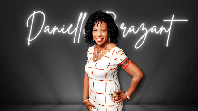 Danielle Brazant smiles in front of neon sign with her name at a photo shoot.