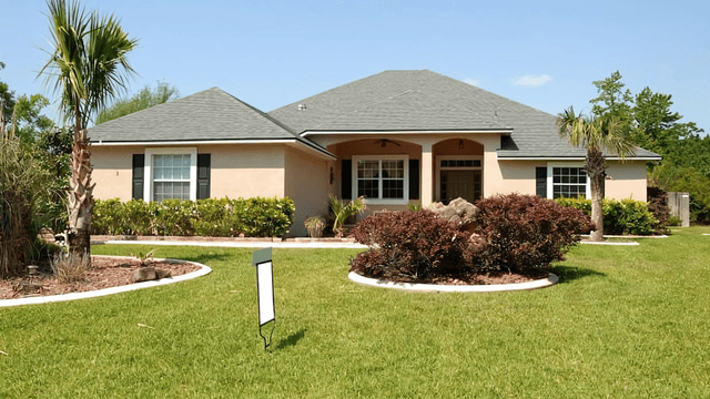 Beautiful home exterior with lush landscaping and palm trees in a sunny neighborhood.