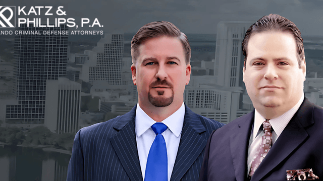 Two suited men in front of a city skyline with the Katz & Phillips, P.A. logo above them.