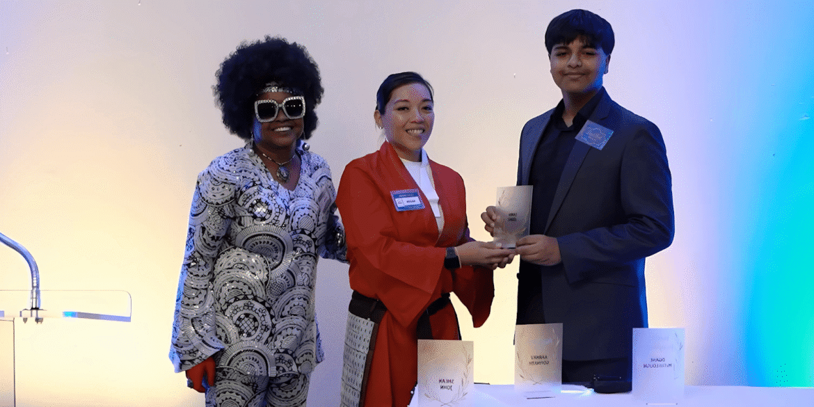 Three students receive an award for their "Home Of My Own" app, raising awareness about homelessness through technology.