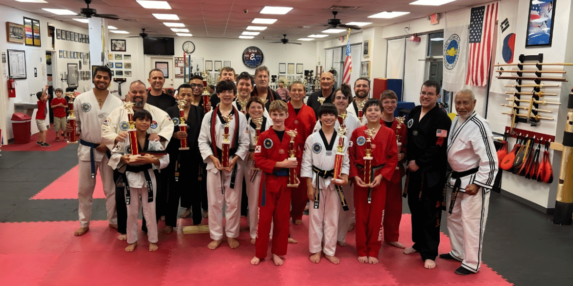 "Grandmaster Spillmann with students celebrating martial arts achievements, leadership, and community impact at Global Martial Arts USA."