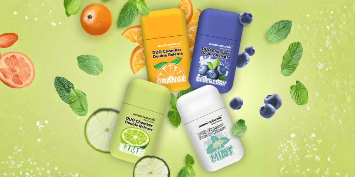 Four Aromi Naturals inhalers in fruity flavors: Orange, Lime, Blueberry, and Mint, surrounded by mint leaves and citrus slices.