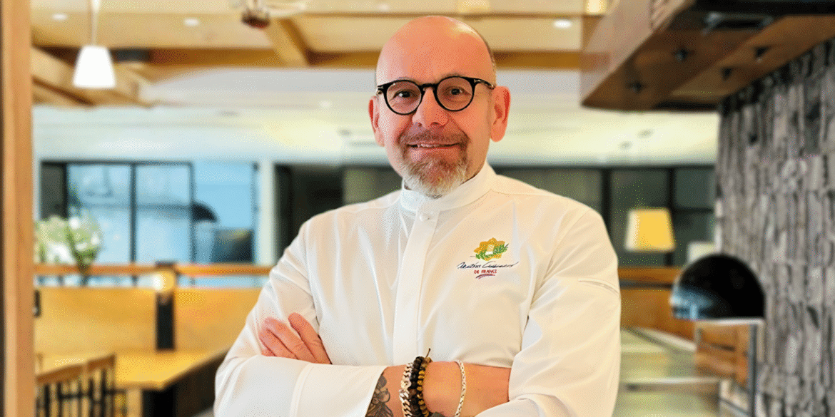 Chef Eric Truglas smiling in a restaurant, representing resilience and mentorship behind his Stolen Knives culinary philosophy.
