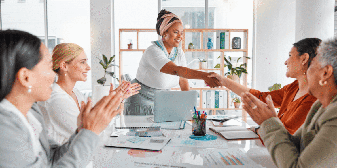 "Dr. Rita Reneé leading a business meeting with women, fostering empowerment, collaboration, and feminine leadership in a professional setting."