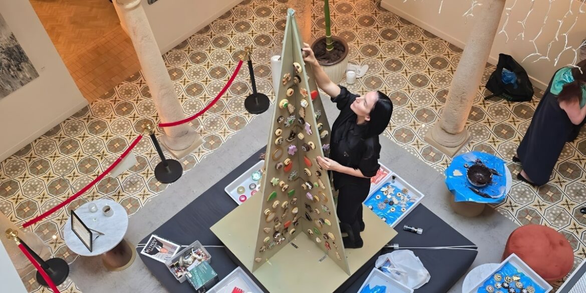 Debbie Wingham assembling a towering cookie tree at La Fonda Heritage Hotel, surrounded by festive decorations and treats.