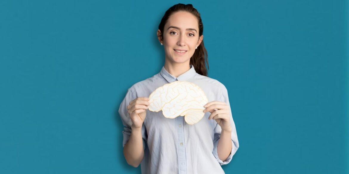 The image shows a woman holding a brain model, representing cognitive health, mental wellness, and brain care support.