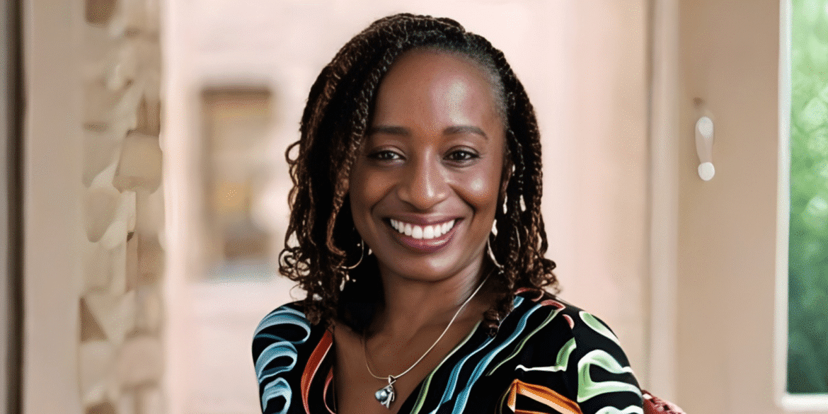 Illyasha Peete smiling confidently, wearing a colorful shirt, with a soft background.