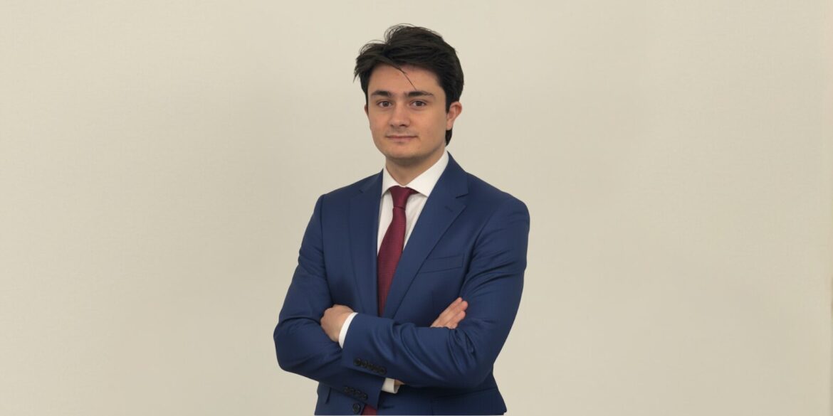 Marcos Agustín, in a blue suit and white shirt, embodies the vision of OpenMacro for accessible global macro investing.