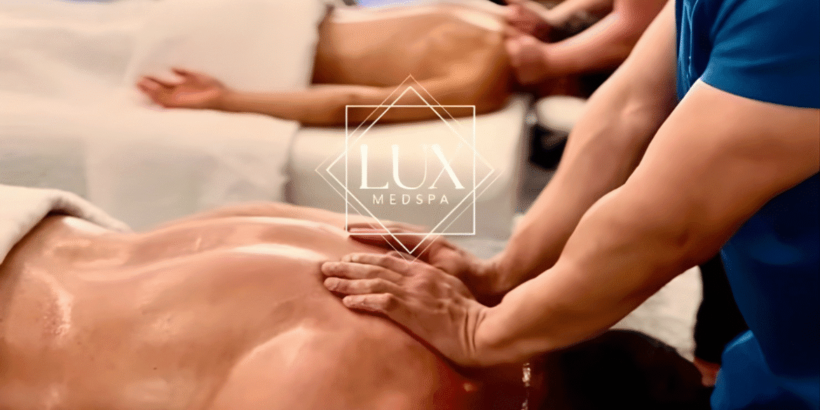 Massage therapist applying oil to client's back at Lux MedSpa treatment room.