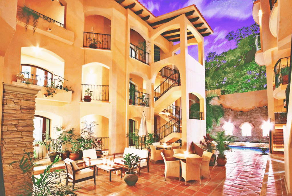 Courtyard seating and pool at Acanto Hotel Playa del Carmen illuminated at dusk.